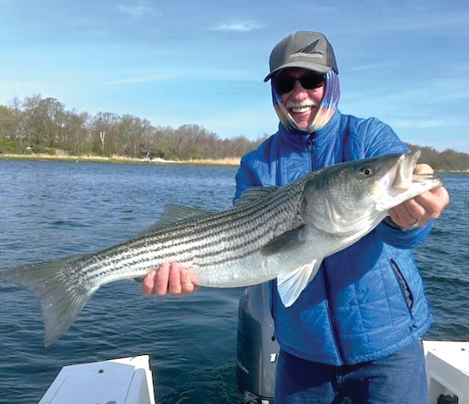 SPRING STRIPED BASS: Jim Lundy with a spring striped bass caught in the East Passage of Narragansett Bay off Prudence Island. (Photo by Fred DeFinis)